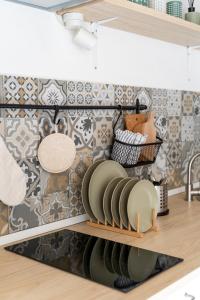 a kitchen with a shelf with plates on it at Loft 35 - private parking in Quartu SantʼElena