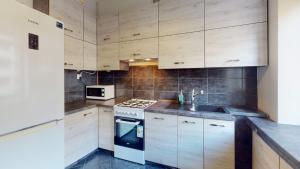 a kitchen with wooden cabinets and a sink and a stove at roomspoznan pl - Ogrodowa 9 - 24h self check-in in Poznań