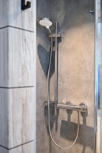eine Dusche mit Duschkopf an der Wand in der Unterkunft Roatel Schipkau (A13) my-roatel-com in Schipkau