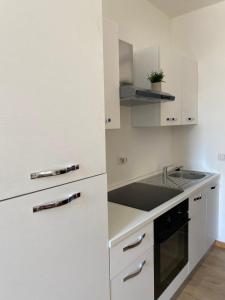 Una cocina blanca con fregadero y refrigerador. en La Casetta Appartamento Parrano, en Parrano