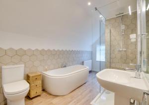 a bathroom with a tub and a toilet and a sink at Uwch Ogwen in Bethesda