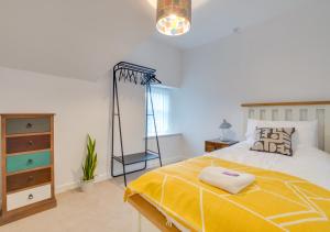 a bedroom with a large bed with a yellow blanket at Uwch Ogwen in Bethesda