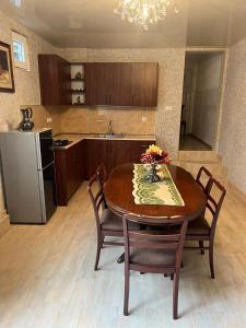 a kitchen with a table and chairs and a refrigerator at Kutaisi City Heart Apartment in Kutaisi