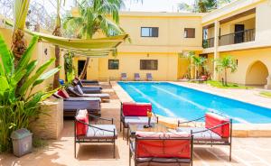 a swimming pool with lounge chairs and a hotel at Hotel la Coccinelle in Bamako