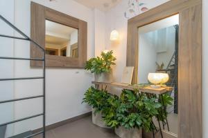 einen Flur mit einem Spiegel und einem Tisch mit Pflanzen in der Unterkunft Mar Colonia in Colonia Sant Jordi + 26 Fotos