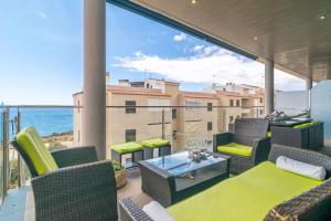 a balcony with chairs and tables and a view of the ocean at Mar Colonia in Colonia Sant Jordi