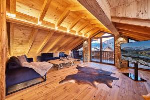 uma sala de estar com um sofá, uma mesa e uma televisão em Chalet Alpi em Garmisch-Partenkirchen