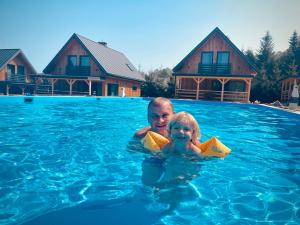 a man and a little girl in a swimming pool at Na Jasieniu in Ustrzyki Dolne