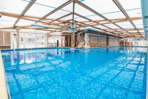 a large indoor swimming pool with blue water at Balneo & SPA Hotel Aura in Velingrad
