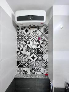 a bathroom with a black and white patterned wall at StudiO Le Thanh Ton R302 -Japanese Town- Saigon Central in Ho Chi Minh City