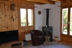 a living room with a tv and a wood stove at Les 2 Sabots in Nendaz