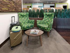 sleep 'n fly Sleep Lounge, A-Gates Terminal 3 - TRANSIT ONLY في دبي: غرفة بها كرسيين وطاولة وحقيبة
