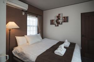 a bedroom with a bed with white towels on it at Shinkyo Inn in Nikko