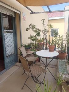 una mesa y sillas en un patio con plantas en Can ventura, en Deltebre