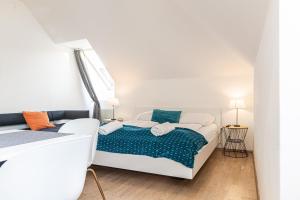 a white bedroom with a bed and two lamps at Vibrant Aparment perfect for Long Stays in Vienna