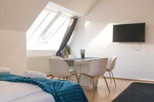 a bedroom with a table and chairs and a tv at Vibrant Aparment perfect for Long Stays in Vienna