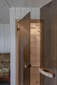 una ducha con puerta de cristal en una habitación en House Perkūno al 59B, en Kaunas