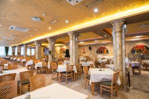 a restaurant with tables and chairs in a room at Balneo & SPA Hotel Aura in Velingrad +82 photos