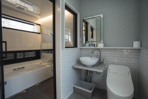 a bathroom with a sink and a toilet and a tub at Shinkyo Inn in Nikko +50 photos