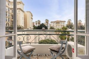 balkon z dwoma krzesłami i stołem na balkonie w obiekcie Suite Flora Five stars Holiday house w Nicei