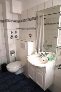 a white bathroom with a toilet and a sink at Happy 1 in Quierschied