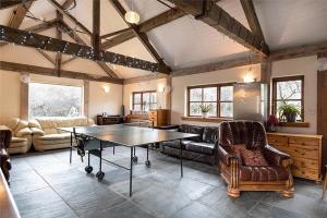 a living room with a table and leather chairs at Y Beudy, Converted Former Dairy in Conwy