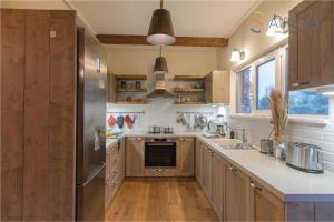 a kitchen with wooden cabinets and a stainless steel refrigerator at Kalista apartment Airport by Airstay in Spata