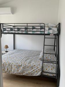 a bedroom with a bunk bed with a ladder at Agréable maison de ville clim/piscine/jardin in Nîmes