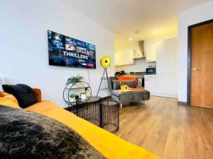 a living room with a yellow bed and a kitchen at Central Luton apartment by Hostaguest in Luton