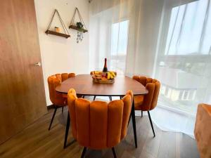 a dining room table with orange chairs and a bottle of wine at Central Luton apartment by Hostaguest in Luton