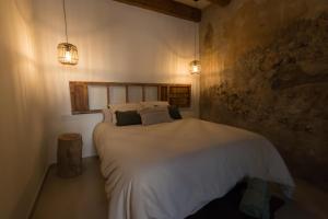 a bedroom with a large bed with white sheets and pillows at CASA ALKAPEPE 