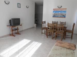 ein Wohnzimmer mit einem Tisch und Stühlen sowie einem TV in der Unterkunft Apartment in Razanj with sea view, terrace, air conditioning, WiFi 5150-2 in Ražanj