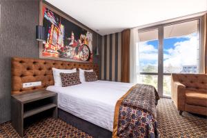 a hotel room with a bed and a window at Resort Hotel Elija in Šventoji