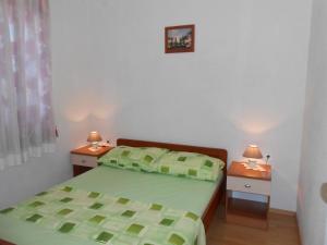 ein Schlafzimmer mit einem grünen Bett und zwei Nachttischen in der Unterkunft Apartment in Razanj with sea view, terrace, air conditioning, WiFi 5150-2 in Ražanj