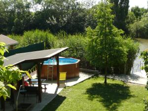 un jardín con bañera de hidromasaje y un árbol en Álomzug Vendégház Szarvas, en Szarvas