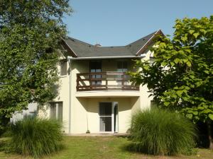 Una gran casa blanca con balcón. en Álomzug Vendégház Szarvas, en Szarvas