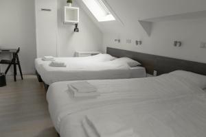 um grupo de quatro camas num quarto em Hotel de la Bourse em Maastricht