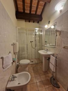 uma casa de banho com 2 lavatórios, um chuveiro e um WC. em Agriturismo e Cantina La Sabbiona em Faenza