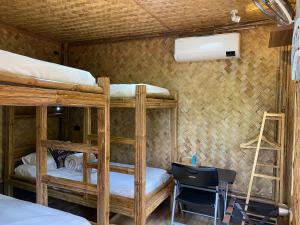 a room with three bunk beds and a desk at Hidden Haven Coron in Coron