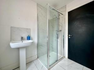 a bathroom with a glass shower and a sink at Lathom Road Central in Southport