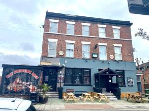 un edificio de ladrillo con mesas delante en Merseyside en Birkenhead