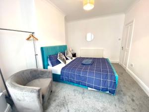 a bedroom with a blue bed and a chair at Merseyside in Birkenhead
