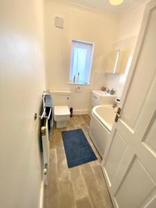 a bathroom with a white tub and a toilet and a window at Merseyside in Birkenhead