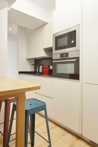 a white kitchen with a table and a microwave at The Rentals Collection - Triunfo in San Sebastián