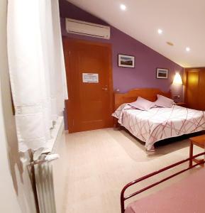 a bedroom with a bed and a purple wall at Hostal Rural Casa Castro in Alberuela de la Liena