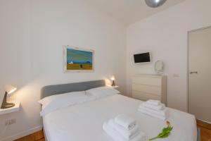 a bedroom with a white bed with towels on it at BnButler - Verona 12, Porta Romana District in Milan