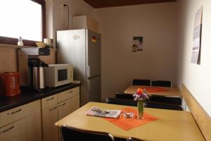 a kitchen with two tables and a refrigerator at Hostel Pinneberg in Pinneberg