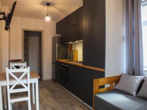 cocina con sofá y taburete en una habitación en Apartament Plac Piastowski 1, en Jelenia Góra