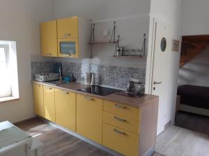 a kitchen with yellow cabinets and a sink at Apartment Vignole in Portorož