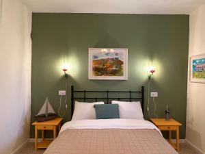 ein Schlafzimmer mit einem Bett mit einer grünen Wand in der Unterkunft Casa Camellia metula in Metulla